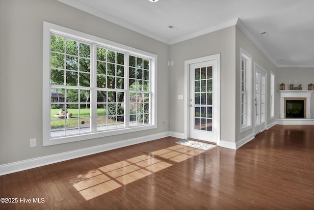 1306 Wakefield Ct, Winnabow, NC 28479 - unfurnished living room featuring wood finished floors, healthy amount of natural light, baseboards, and crown molding