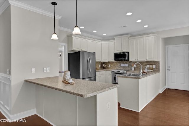 1306 Wakefield Ct, Winnabow, NC 28479 - kitchen featuring stainless steel appliances, a peninsula, a sink, crown molding, and decorative backsplash