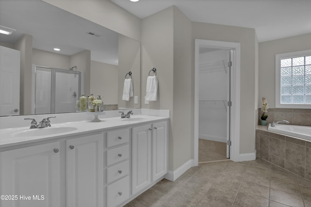 1306 Wakefield Ct, Winnabow, NC 28479 - bathroom with a stall shower, baseboards, double vanity, a spacious closet, and a garden tub