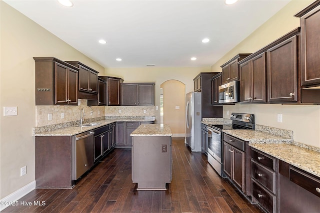 113 Kingsmill Dr, Pikeville, NC 27863 - kitchen with stainless steel appliances, dark brown cabinets, arched walkways, dark wood-style floors, and recessed lighting
