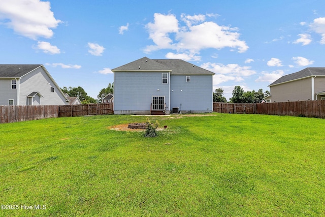 113 Kingsmill Dr, Pikeville, NC 27863 - rear view of house featuring a fenced backyard and an outdoor fire pit