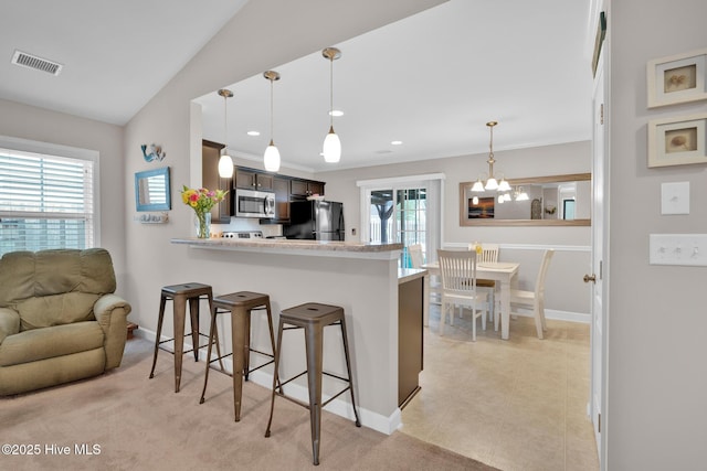 2017 Willow Stone Ct, Leland, NC 28451 - kitchen with stainless steel microwave, freestanding refrigerator, a kitchen breakfast bar, light countertops, and baseboards