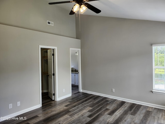 5024 Gate Post Ln, Wilmington, NC 28412 - unfurnished bedroom with a spacious closet, dark wood finished floors, baseboards, a towering ceiling, and connected bathroom