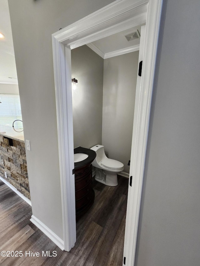 5024 Gate Post Ln, Wilmington, NC 28412 - bathroom with crown molding, wood finished floors, baseboards, and toilet