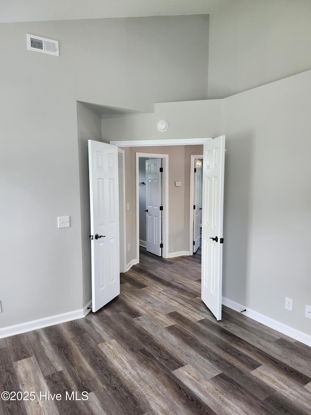 5024 Gate Post Ln, Wilmington, NC 28412 - unfurnished bedroom featuring baseboards, dark wood finished floors, and high vaulted ceiling