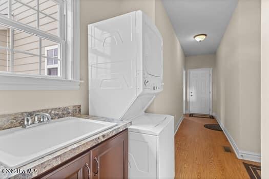375 Summit Farms Trl, Moyock, NC 27958 - washroom with stacked washer / drying machine, light wood finished floors, cabinet space, and baseboards