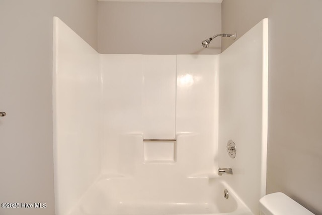 bathroom featuring toilet and washtub / shower combination