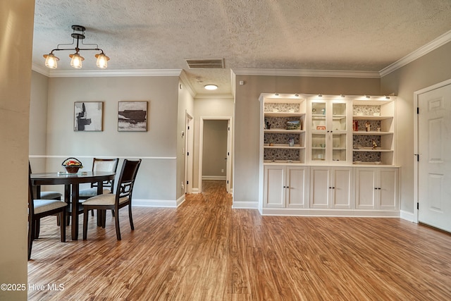 60 Pine Lake Rd, Southport, NC 28461 - dining space featuring wood finished floors, a textured ceiling, baseboards, and ornamental molding