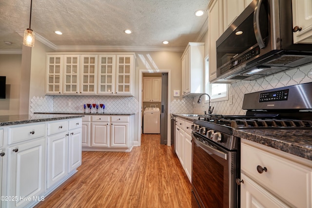 60 Pine Lake Rd, Southport, NC 28461 - kitchen featuring gas range, stainless steel microwave, a sink, washer / clothes dryer, and crown molding