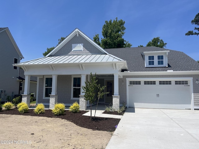 482 Sailor Sky Way Unit 401, Hampstead, NC 28443 - craftsman-style house with a porch, a standing seam roof, a garage, concrete driveway, and roof with shingles