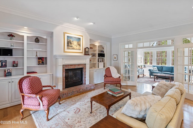 3792 Bancroft Pl, Southport, NC 28461 - living room with crown molding, light wood finished floors, built in shelves, french doors, and a fireplace