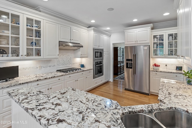 3792 Bancroft Pl, Southport, NC 28461 - kitchen with stainless steel appliances, ornamental molding, under cabinet range hood, white cabinets, and recessed lighting