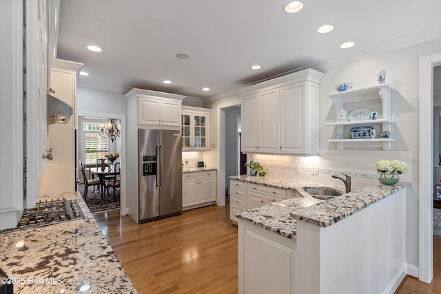 3792 Bancroft Pl, Southport, NC 28461 - kitchen with appliances with stainless steel finishes, ornamental molding, backsplash, a sink, and white cabinets