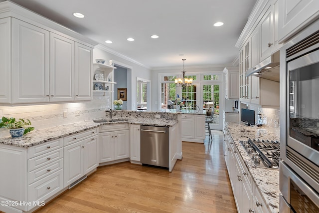 3792 Bancroft Pl, Southport, NC 28461 - kitchen featuring stainless steel appliances, a sink, a chandelier, crown molding, and a peninsula