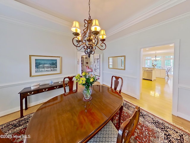 3792 Bancroft Pl, Southport, NC 28461 - dining space featuring a chandelier, ornamental molding, and light wood-style floors