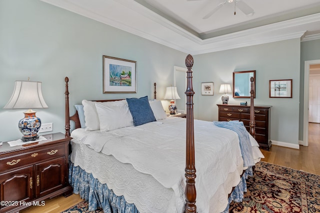3792 Bancroft Pl, Southport, NC 28461 - bedroom with light wood-type flooring, crown molding, ceiling fan, and a tray ceiling