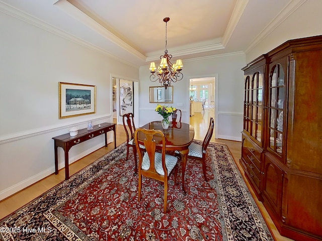 3792 Bancroft Pl, Southport, NC 28461 - dining room with a raised ceiling, a chandelier, crown molding, and light wood finished floors