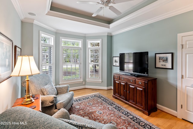 3792 Bancroft Pl, Southport, NC 28461 - living room with light wood finished floors, a raised ceiling, a ceiling fan, ornamental molding, and baseboards