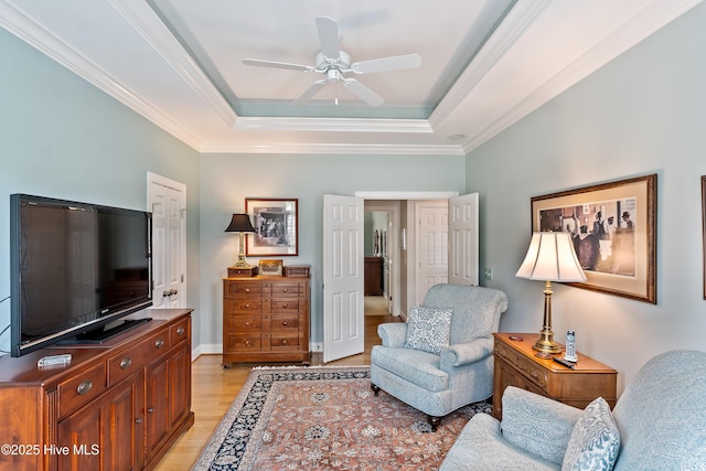 3792 Bancroft Pl, Southport, NC 28461 - living room with light wood-style floors, a raised ceiling, ceiling fan, and ornamental molding