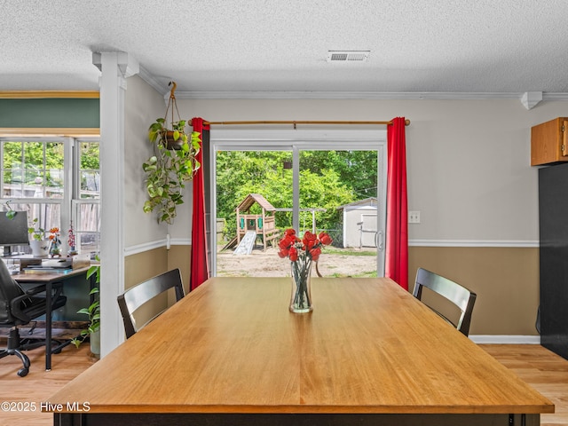 245 Parnell Rd, Hubert, NC 28539 - dining room featuring wood finished floors, a textured ceiling, and ornamental molding