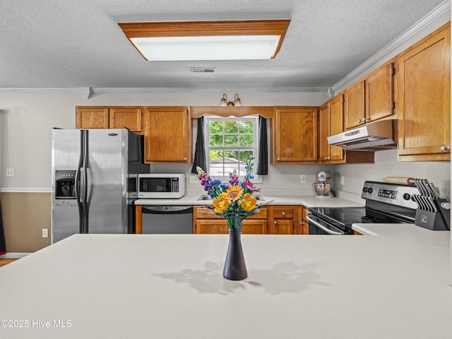 245 Parnell Rd, Hubert, NC 28539 - kitchen featuring stainless steel appliances, under cabinet range hood, a textured ceiling, light countertops, and brown cabinetry