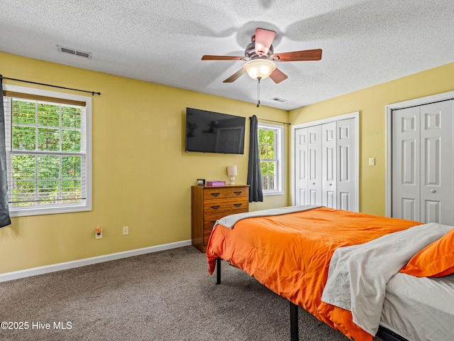 245 Parnell Rd, Hubert, NC 28539 - carpeted bedroom with a textured ceiling, multiple windows, multiple closets, baseboards, and ceiling fan