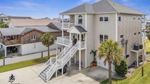 9089 W 9th St, Surf City, NC 28445 - rear view of property featuring a balcony, a shingled roof, and a lawn
