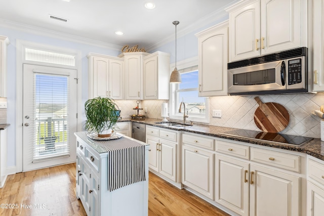 9089 W 9th St, Surf City, NC 28445 - kitchen featuring stainless steel appliances, a sink, dark stone countertops, pendant lighting, and light wood-style floors