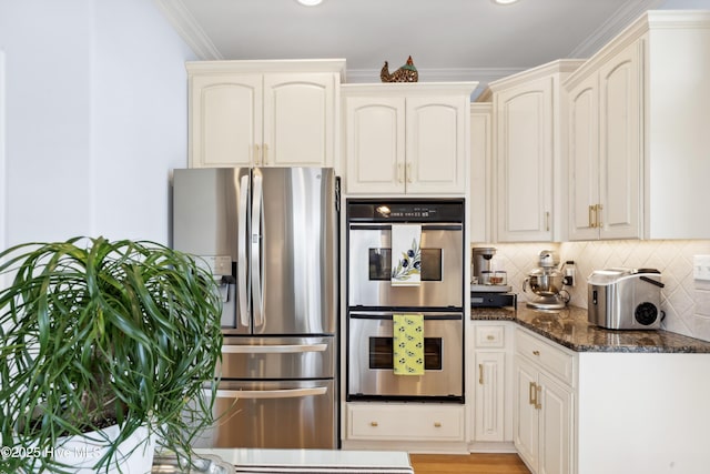 9089 W 9th St, Surf City, NC 28445 - kitchen featuring stainless steel appliances, dark stone counters, ornamental molding, backsplash, and cream cabinets