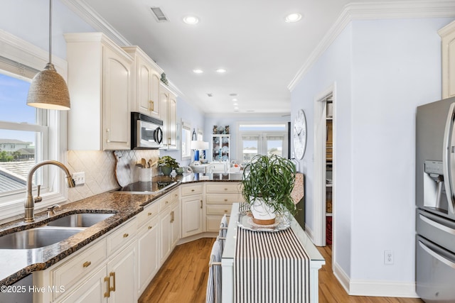 9089 W 9th St, Surf City, NC 28445 - kitchen with a sink, stainless steel appliances, light wood-style floors, dark stone countertops, and decorative backsplash