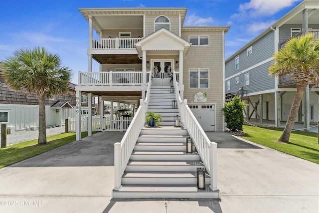 9089 W 9th St, Surf City, NC 28445 - beach home featuring driveway, stairway, an attached garage, a balcony, and french doors