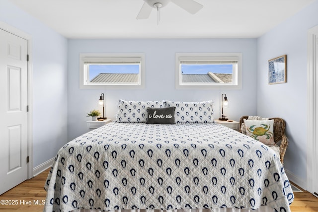 9089 W 9th St, Surf City, NC 28445 - bedroom with light wood finished floors, multiple windows, and ceiling fan
