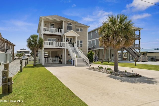 9089 W 9th St, Surf City, NC 28445 - view of front of property with stairway, concrete driveway, a carport, a balcony, and covered porch