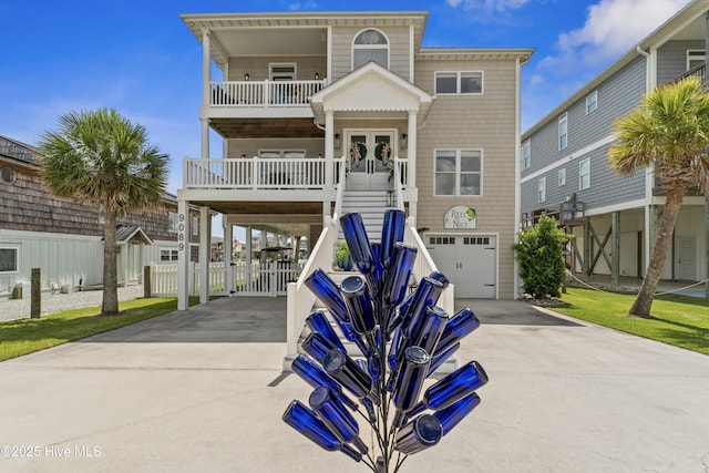 9089 W 9th St, Surf City, NC 28445 - coastal home with concrete driveway, a balcony, a garage, and a carport