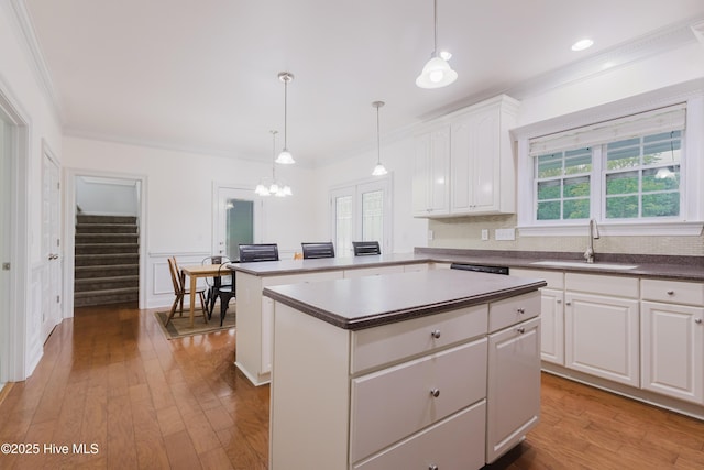 358 Folkstone Rd, Holly Ridge, NC 28445 - kitchen featuring a sink, a kitchen island, healthy amount of natural light, ornamental molding, and white cabinetry