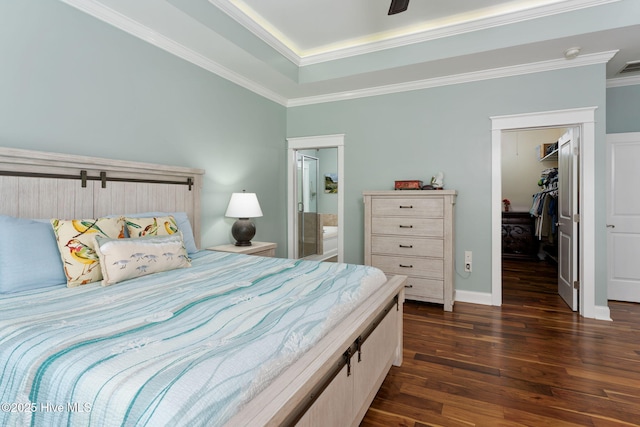 244 Red Fox Run Dr, Wallace, NC 28466 - bedroom featuring dark wood-style flooring, a spacious closet, a closet, ornamental molding, and a tray ceiling
