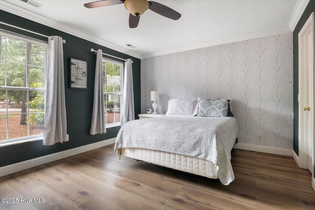 8 Saunders Ln, Pinehurst, NC 28374 - bedroom with ornamental molding, baseboards, wallpapered walls, wood finished floors, and ceiling fan
