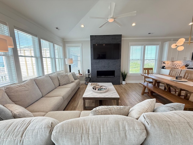 1012 New River Inlet Rd, North Topsail Beach, NC 28460 - living room featuring crown molding, ceiling fan, baseboards, light wood finished floors, and a tile fireplace