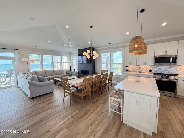 1012 New River Inlet Rd, North Topsail Beach, NC 28460 - kitchen featuring appliances with stainless steel finishes, light countertops, white cabinetry, light wood-style floors, and lofted ceiling