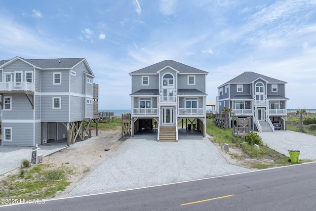 1012 New River Inlet Rd, North Topsail Beach, NC 28460 - coastal inspired home featuring a carport, stairs, driveway, central AC unit, and a shingled roof