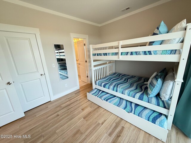 1012 New River Inlet Rd, North Topsail Beach, NC 28460 - bedroom with crown molding, wood finished floors, baseboards, and ensuite bath