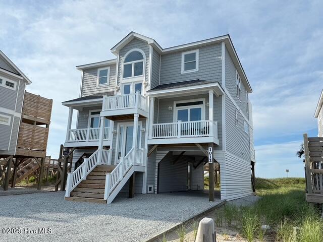 1012 New River Inlet Rd, North Topsail Beach, NC 28460 - coastal inspired home with a carport, gravel driveway, and a balcony