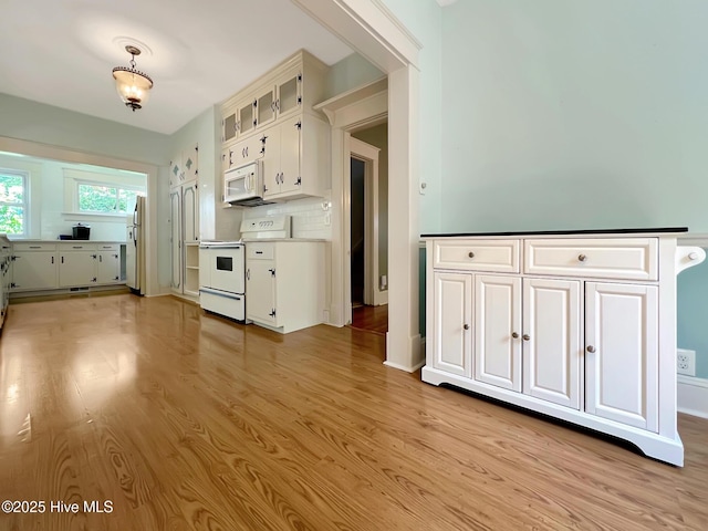 110 Virginia Rd, Edenton, NC 27932 - kitchen featuring white appliances, white cabinetry, light wood-type flooring, and backsplash
