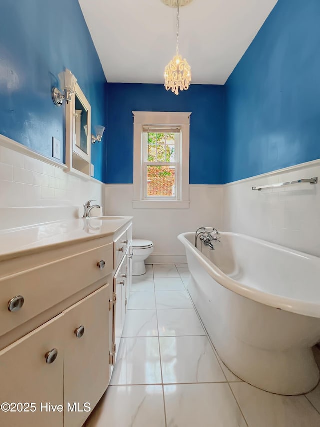 110 Virginia Rd, Edenton, NC 27932 - bathroom featuring a chandelier, a wainscoted wall, vanity, a freestanding bath, and toilet