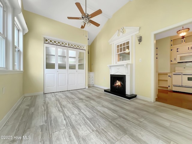110 Virginia Rd, Edenton, NC 27932 - unfurnished living room with a ceiling fan, lofted ceiling, a lit fireplace, and baseboards