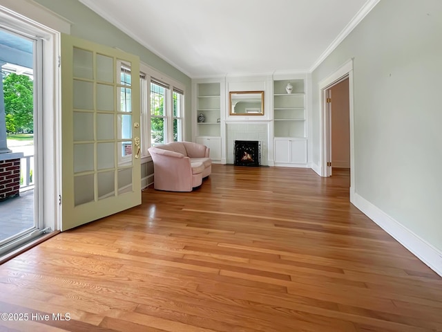 110 Virginia Rd, Edenton, NC 27932 - unfurnished living room featuring ornamental molding, light wood-style floors, a fireplace with flush hearth, built in shelves, and baseboards