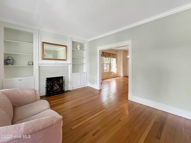 110 Virginia Rd, Edenton, NC 27932 - living area featuring baseboards, ornamental molding, wood finished floors, a brick fireplace, and built in shelves