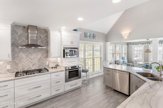 299 Waterway Dr, Sneads Ferry, NC 28460 - kitchen featuring stainless steel appliances, wall chimney exhaust hood, a sink, lofted ceiling, and tasteful backsplash