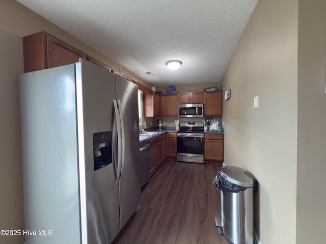 141 Jessie Cir, Hubert, NC 28539 - kitchen with appliances with stainless steel finishes, dark wood-style flooring, dark countertops, and brown cabinetry
