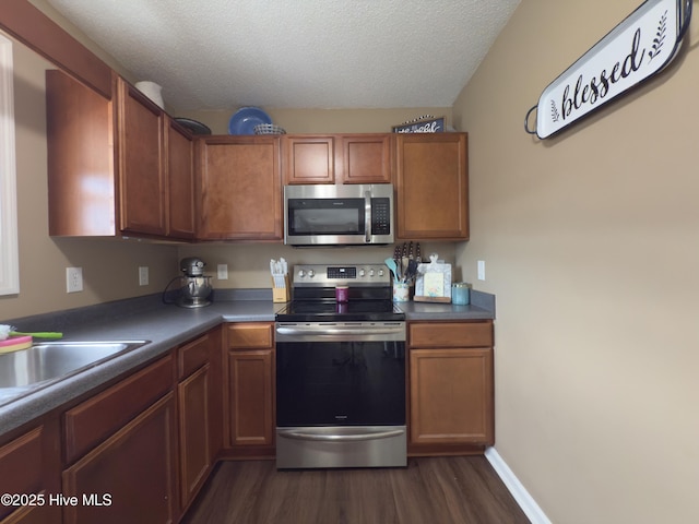 141 Jessie Cir, Hubert, NC 28539 - kitchen featuring appliances with stainless steel finishes, dark wood-style floors, a textured ceiling, and brown cabinets